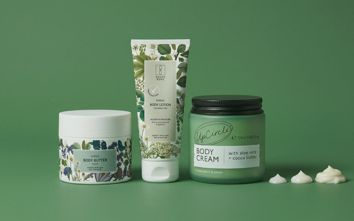 Raunsborg Body Butter Melon, Raunsborg Nordic Body Lotion og UpCircle body cream stillet op fra tyk til tynd på grøn baggrund