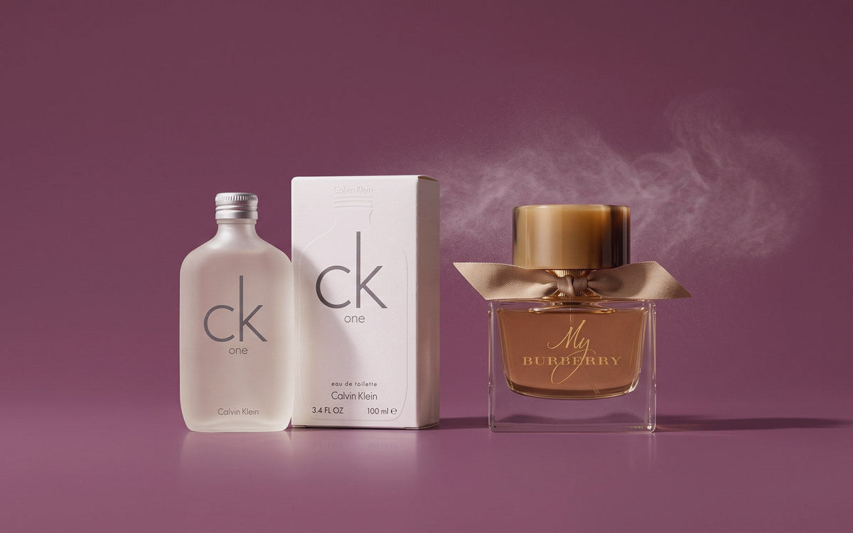 Calvin Klein CK One eau de toilette med æske og Burberry My Burberry eau de parfum på blommefarvet baggrund