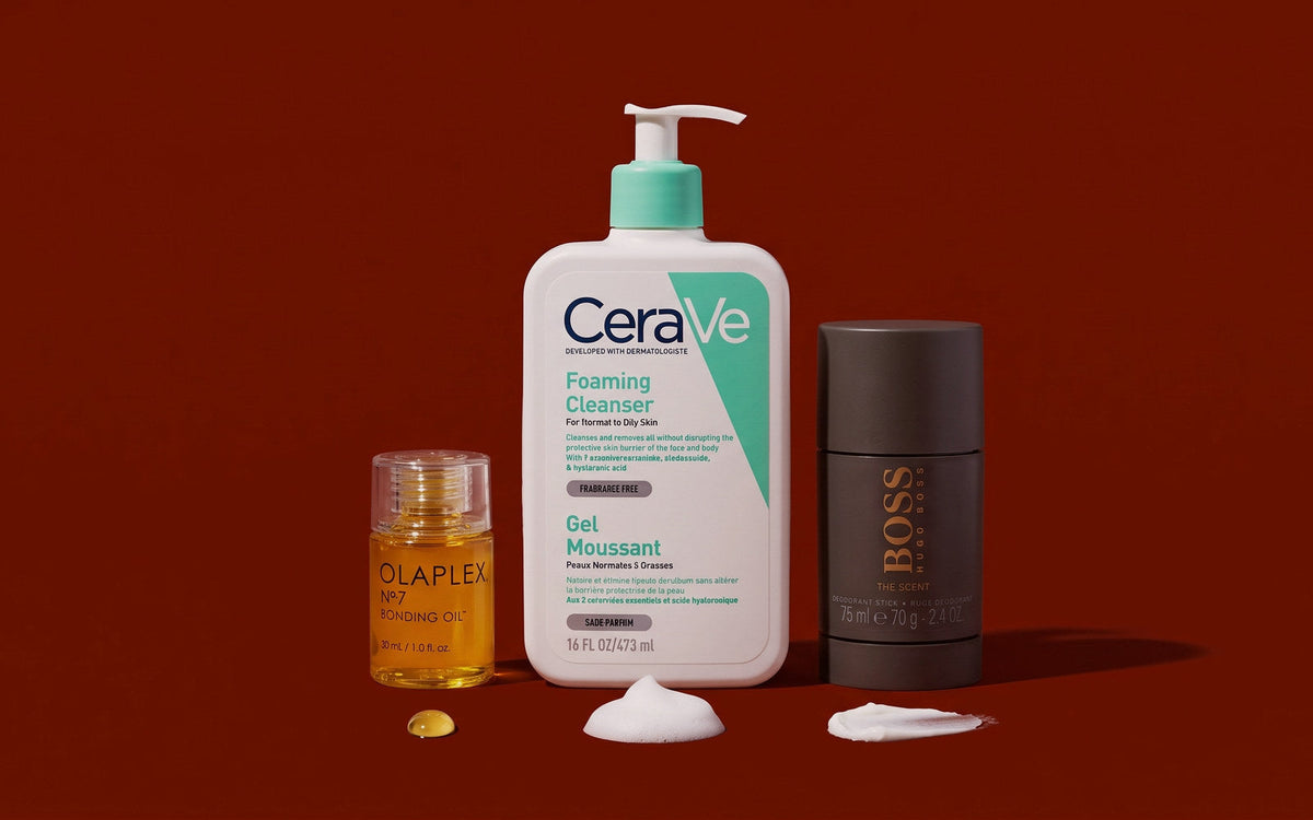 CeraVe Foaming Cleanser, Hugo Boss Boss The Scent Deodorant Stick og Olaplex No. 7 Bonding Oil på mørk rødbrun baggrund