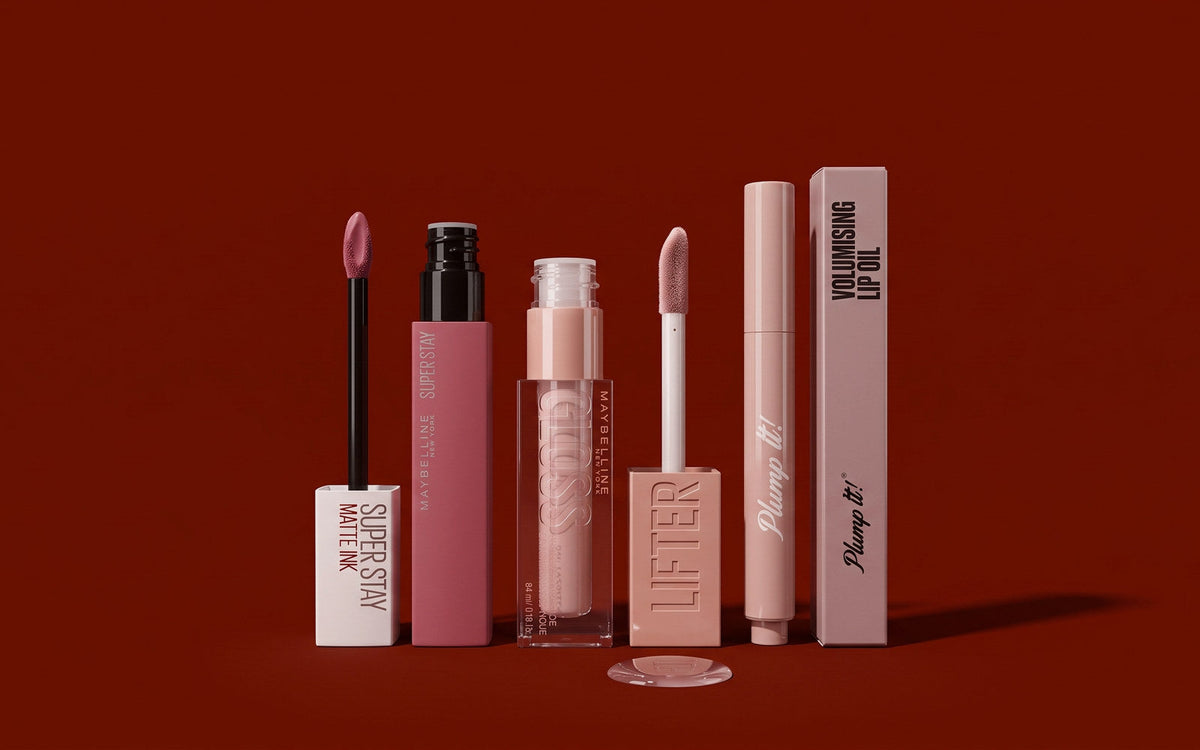 Maybelline SuperStay Matte Ink, Maybelline Lifter Gloss og Plump It! Volumising Lip Oil på mørk rødbrun baggrund