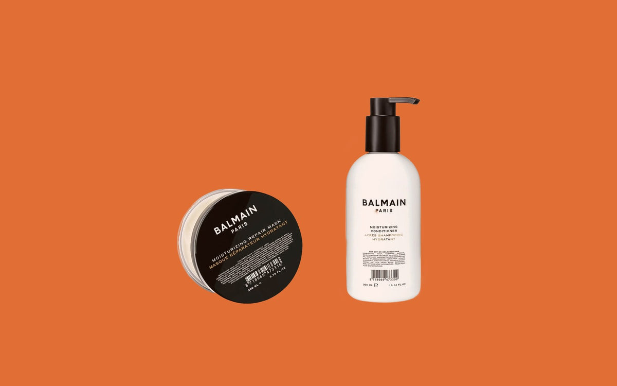 Balmain Moisturizing Repair Mask i sort krukke og Moisturizing Conditioner i hvid pumpeflaske på orange baggrund