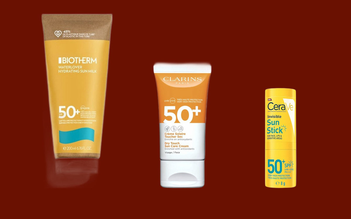 Biotherm Waterlover Sun Milk 200 ml, Clarins Dry Touch solcreme til ansigtet 50 ml og CeraVe Invisible Sun Stick 8 g på mørk rødbrun baggrund